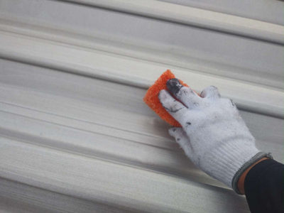 【屋根アルミメッキ鋼板】ケレン作業<br />
<br />
旧塗膜やサビを落としたり、塗装面を平滑でキレイにする作業です。<br />
加えて表面にキズを付けること（目荒らしという作業）で、塗料の密着を良くし、仕上がりの寿命を延ばすという大事な工程です。サビが無くても必ず行います。