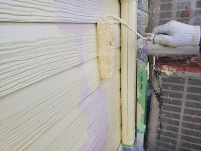 【外壁サイディング】中塗り塗装<br />
<br />
お客様にご指定いただいた、塗料を刷毛とローラーを使い丁寧に塗っていきます。基本的には塗膜を保持するために、手塗り塗装を行います。こちらは低汚染遮熱塗料を塗装します。汚れの付着を防ぎ屋根・外壁の美観を長期間保持してくれるのに加え、紫外線への耐候が高いフッ素樹脂に無機成分を配合しているので耐候性も抜群な塗料です。