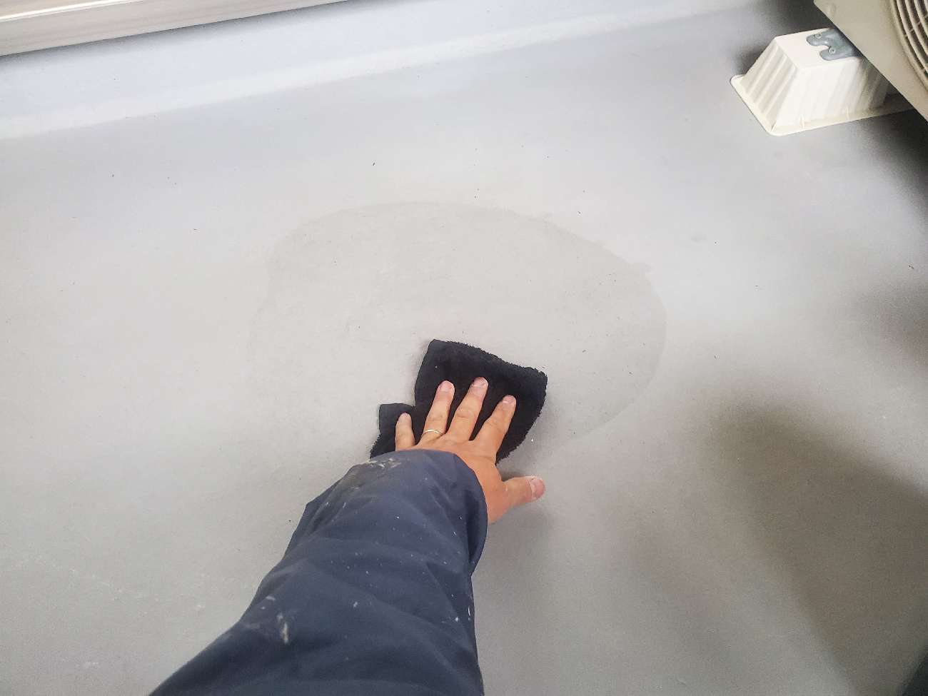 <strong>ベランダ床 下地処理(脱脂)</strong><br>既存の防水面に油分が残っていると新しい防水層が密着しないので、塗装前に脱脂の下地処理をしています。