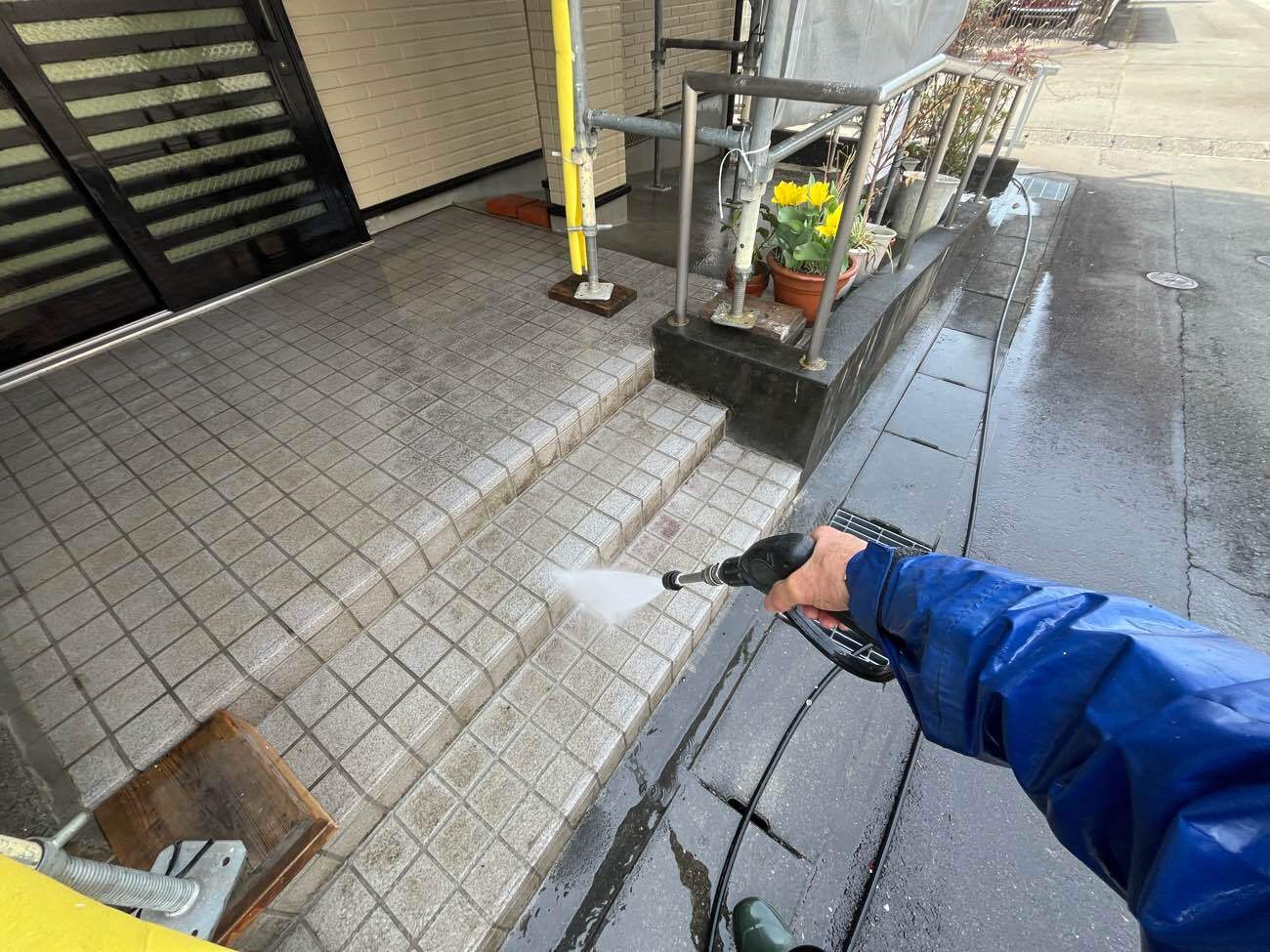 <strong>高圧洗浄(付帯部)</strong><br>塗装はしませんが水圧を調整しながら、玄関ポーチタイルもキレイにしていきます。
