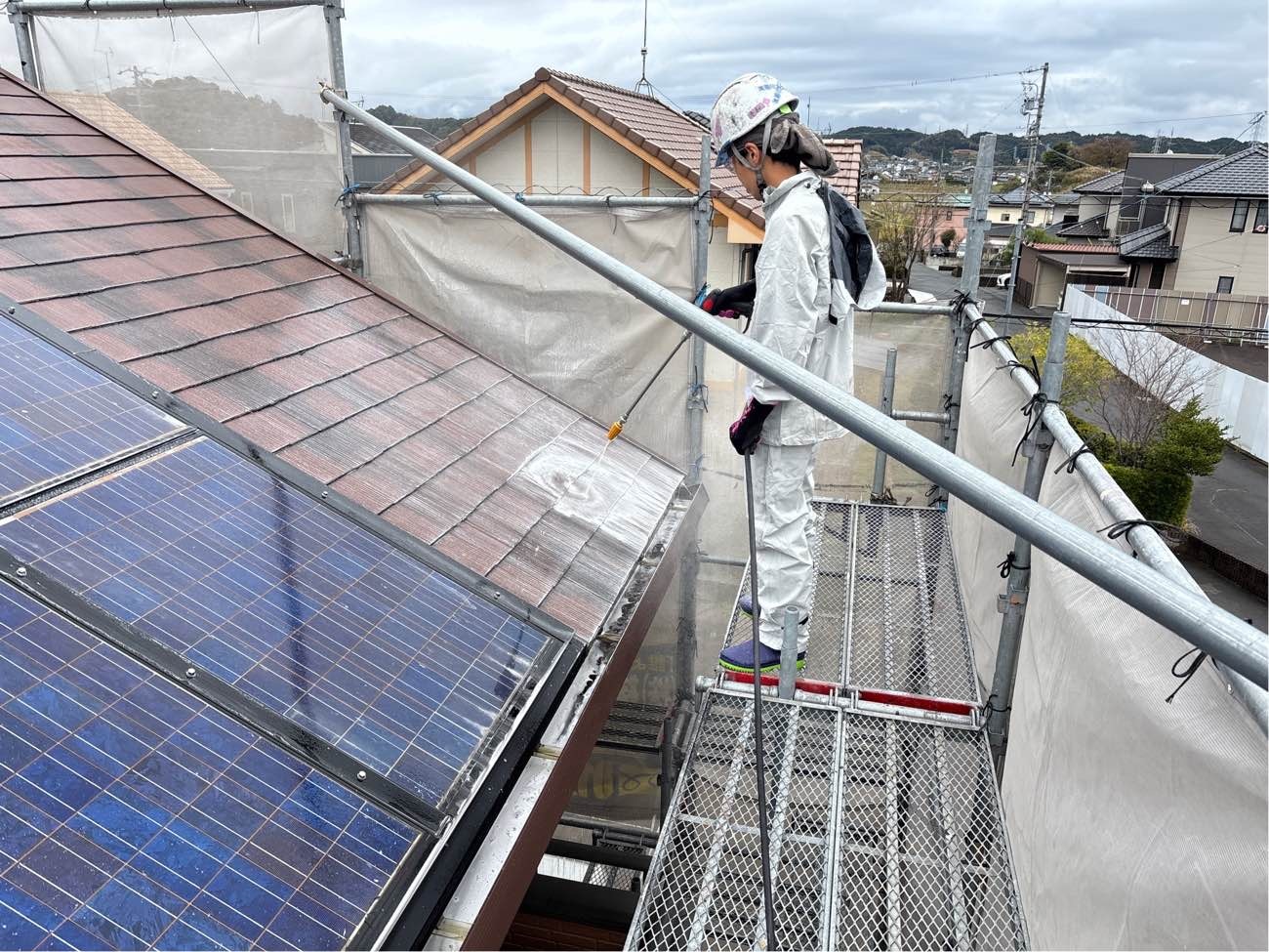 <strong>バイオ洗浄中(屋根)</strong><br>通常洗浄では取り切れない根っ子の部分まで働きかけます。洗浄不十分の下地は、塗装した塗料を栄養にしてカビやコケが塗装前の数倍の量に繁殖する場合があります。バイオ洗浄は細かい部分に潜んでいるカビやコケ、藻や汚れを徹底的に洗い流します。