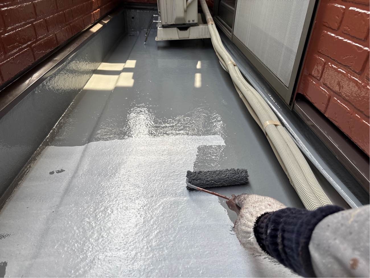 <strong>ベランダ床 トップコート1回目</strong><br>トップコート塗装1回目です。(2回塗装します) FRP防水への付着性と耐候性に優れたトップコートで、紫外線や雨風により塗膜が劣化するのを防止する為の保護塗料で、見た目も美しく回復します。白く見えるのは、下地調整剤です。